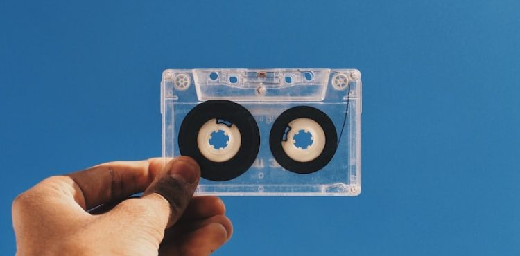 person holding white and black cassette tape
